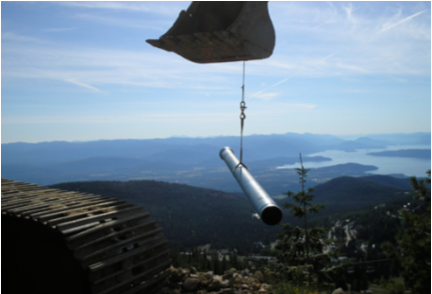 Pipe being lifted into a mountain with a bulldozer