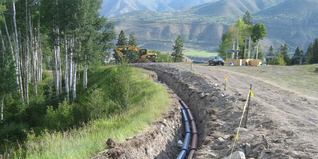 new pipe laid in the ground with mountains in the background