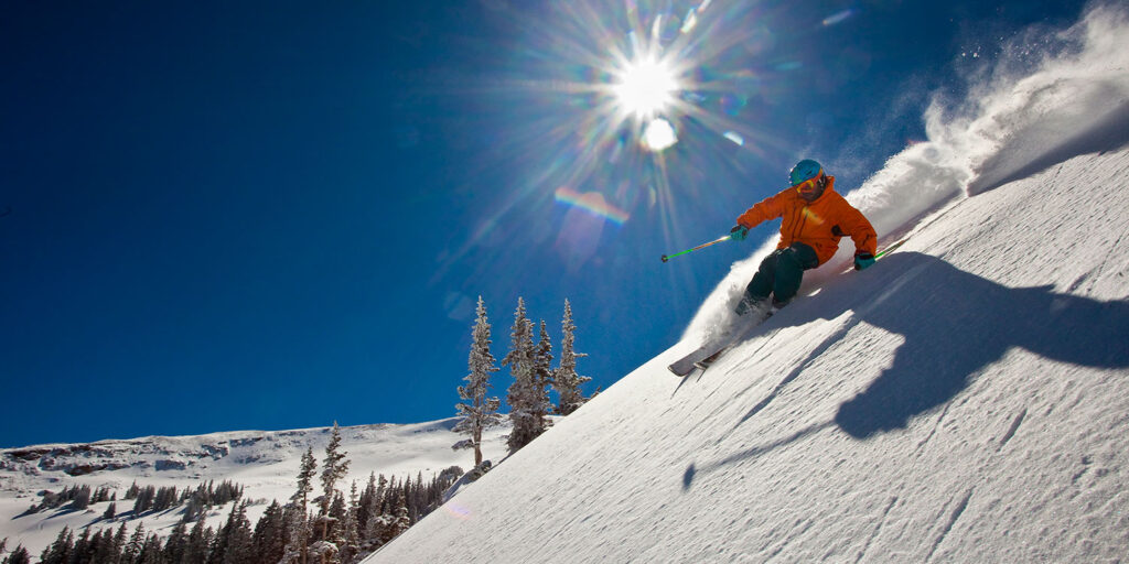 Skier on a steep slope on a sunny day